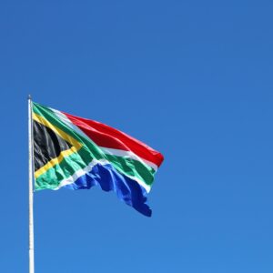 A low angle shot of the South African flag in the wind under the clear blue sky